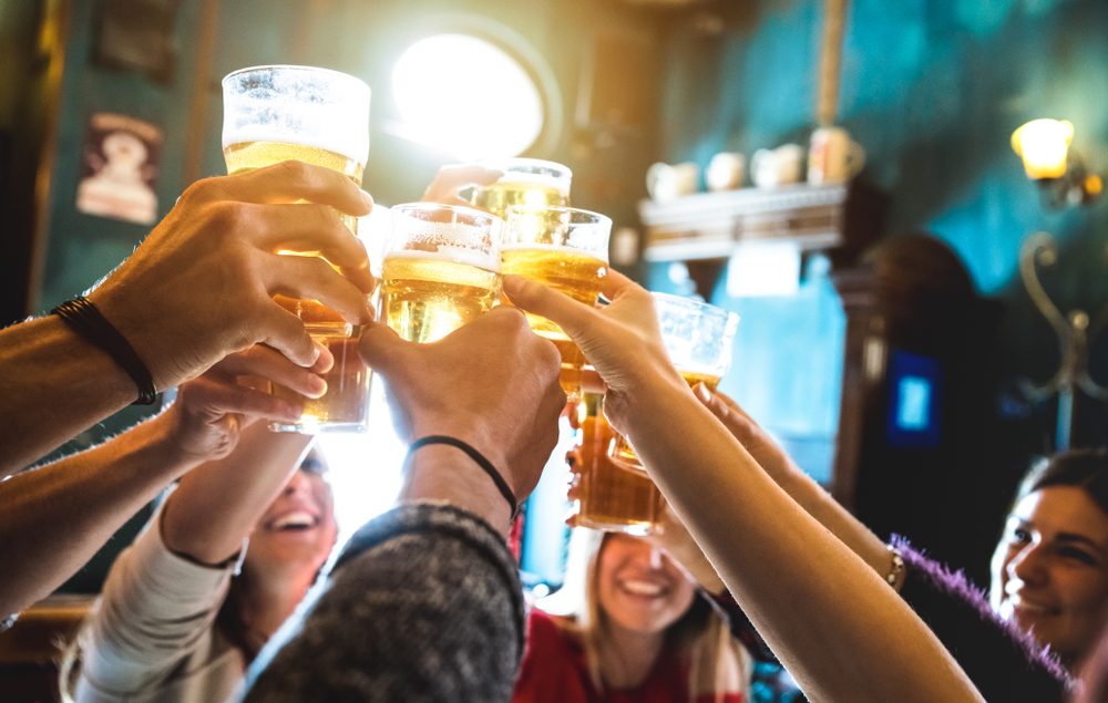 glazen bier die omhooggehouden worden om te proosten