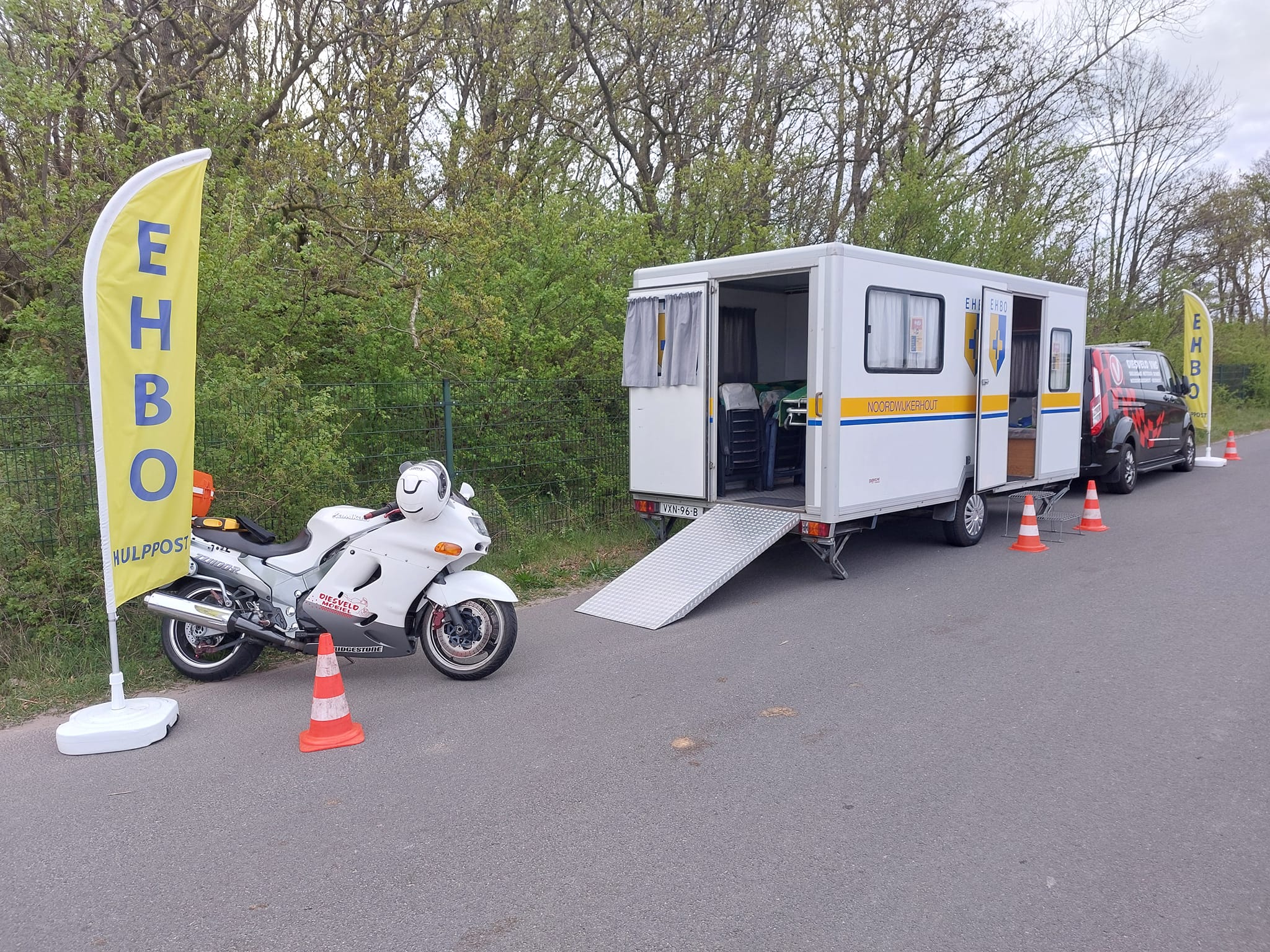EHBO-post met Mobiele HulpverleningsUnit, EHBO-vlaggen en EHBO-motor van EHBO-vereniging Noordwijkerhout.